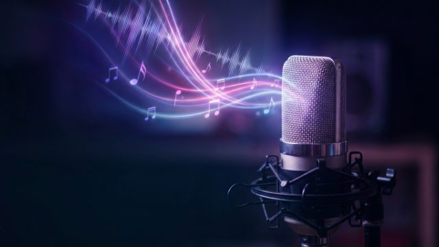 A studio microphone with glowing sound waves