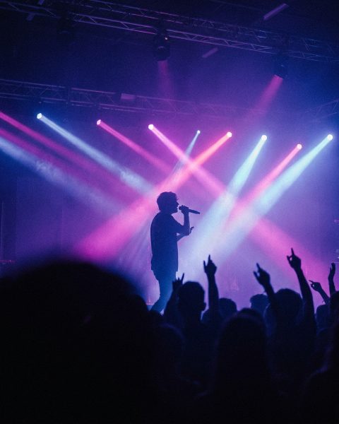 A singer on a neon-lit concert stage